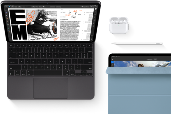 iPad Pro attached to Magic Keyboard, front exterior, space black color, rounded corners, black display bezel, open, display showing article editing app with text and photograph of a woman playing music, Airpods 4 in open case, blue Smart Folio cover on iPad Pro with Apple Pencil Pro resting atop device, cover slightly open revealing display